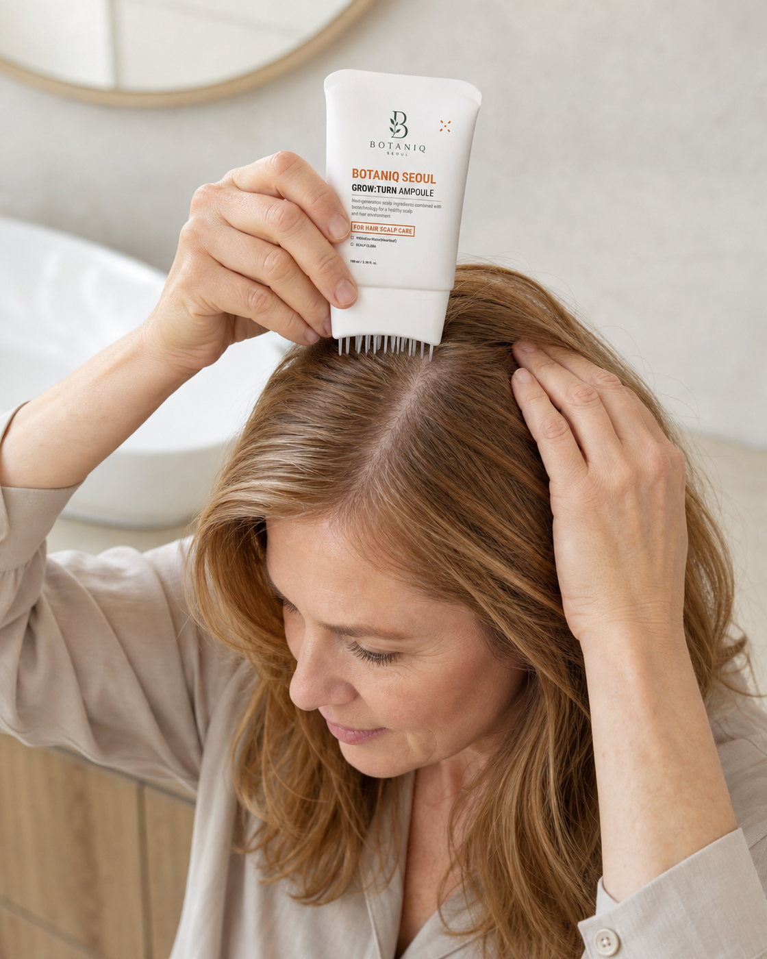 Woman applying Hairfoli along a naturally widened scalp part
